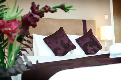 a bedroom with a bed with purple and white pillows at The Spires Serviced Apartments Glasgow in Glasgow