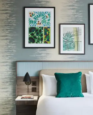 a bedroom with a bed and two framed pictures on the wall at Leonardo Royal Hotel Glasgow in Glasgow