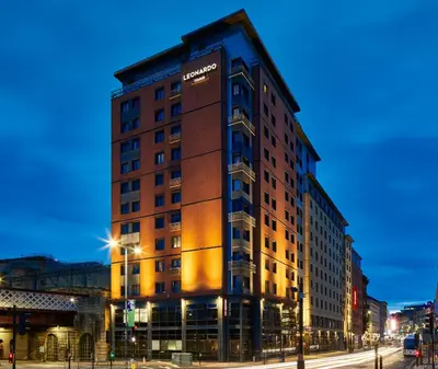 a tall building on a city street at night at Leonardo Royal Hotel Glasgow in Glasgow