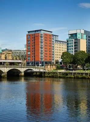a bridge over a river in a city with buildings at Leonardo Royal Hotel Glasgow in Glasgow