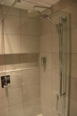 a bathroom with a shower with a glass door at The Golden Jubilee Hotel in Clydebank