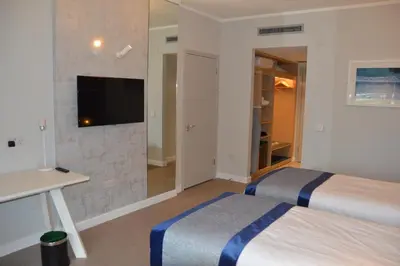 a hotel room with two beds and a flat screen tv at The Golden Jubilee Hotel in Clydebank