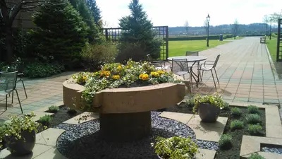 a large stone planter with flowers in a garden at The Golden Jubilee Hotel in Clydebank