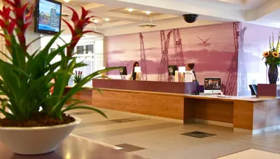 a potted plant sits in front of a reception desk at The Golden Jubilee Hotel in Clydebank