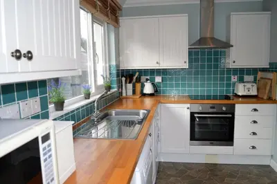 a kitchen with white cabinets and a sink at Craignethan in Kames