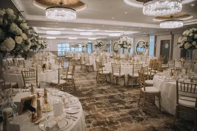 a banquet room with white tables and chairs and chandeliers at The Gailes Hotel & Spa in Irvine