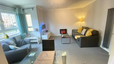 a living room with a couch and a table at Paisley Central Apartment #3 in Paisley