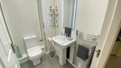 a small bathroom with a toilet and a sink at Paisley Central Apartment #3 in Paisley