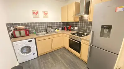 a kitchen with a washer and a sink and a refrigerator at Paisley Central Apartment #3 in Paisley