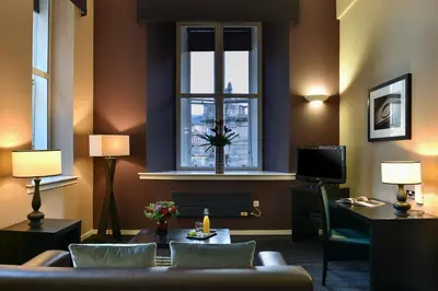 a living room with a couch and a window at Fraser Suites Glasgow in Glasgow