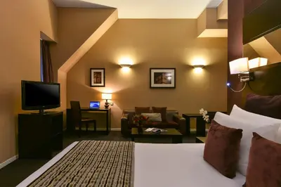 a hotel room with a bed and a tv at Fraser Suites Glasgow in Glasgow