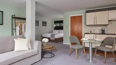 a living room with a couch and a table in a room at Fraser Suites Glasgow in Glasgow