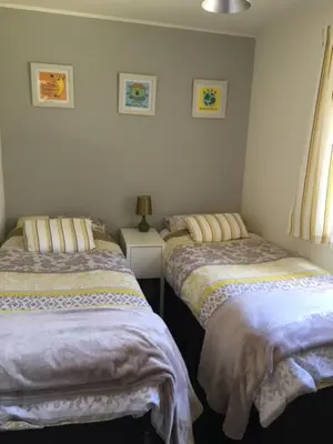 a bedroom with two beds and a table with a lamp at Creity Hall Chalet in Stirling