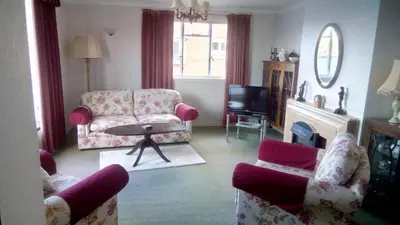 a living room with a couch and a chair and a tv at bayviewapartment in Oban