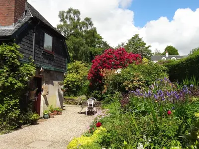 a garden in front of a house with flowers at Coach House at The Glen in Helensburgh