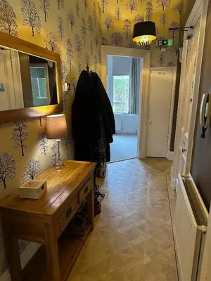 a hallway with a table and a lamp on a wall at The Coates Gardens Residence in Edinburgh