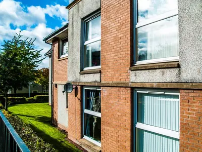 a brick building with windows on the side of it at King Court Apartment in Motherwell