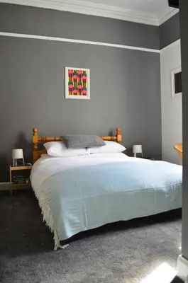 a bedroom with a large bed with a blue blanket at Briar Brae Bed & Breakfast in Stranraer