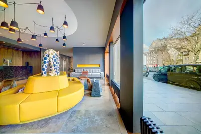 a yellow couch in a room with a street at Apex City of Edinburgh Hotel in Edinburgh