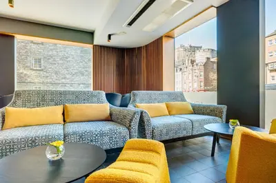 a living room with a couch and a table at Apex City of Edinburgh Hotel in Edinburgh