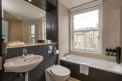 a bathroom with a sink toilet and a window at Apex City of Edinburgh Hotel in Edinburgh