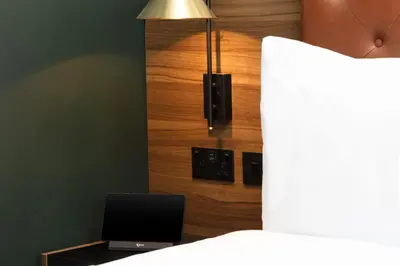 a bedroom with a bed and a desk with a laptop at Four Points by Sheraton Edinburgh in Edinburgh