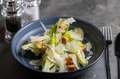 a blue bowl of food with lettuce on a table at Four Points by Sheraton Edinburgh in Edinburgh