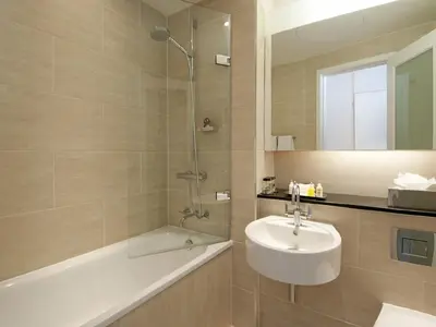 a bathroom with a sink and a shower and a bath tub at Apex Grassmarket Hotel in Edinburgh