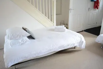a white bed with white sheets and pillows at Glasgow Hampden House in Glasgow