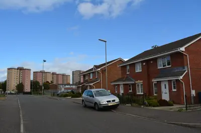a car parked on the side of a street with houses at Glasgow Hampden House in Glasgow
