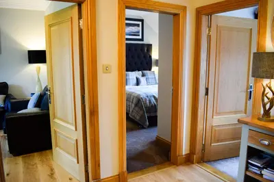 a room with a bed and a door leading to a bedroom at Benoch Lomond Castle in Alexandria