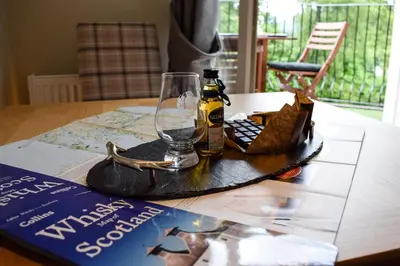 a bottle of beer and a glass on a table at Benoch Lomond Castle in Alexandria