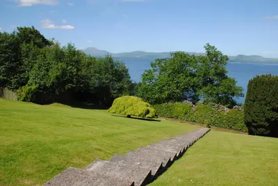 a grassy field with a large bush in the middle at Benoch Lomond Castle in Alexandria