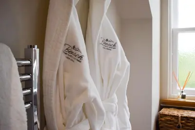 a group of white towels hanging in a bathroom at Benoch Lomond Castle in Alexandria