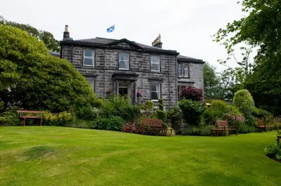 an old house with a green lawn in front of it at Garvock House Hotel in Dunfermline
