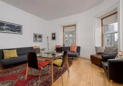 a living room with a couch and a table and chairs at The Lothian Road Residence in Edinburgh