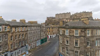 a city street with buildings with a castle in the background at Doubletree by Hilton Edinburgh City Centre in Edinburgh
