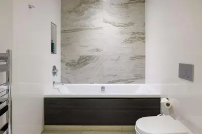 a bathroom with a toilet and a bath tub at Doubletree by Hilton Edinburgh City Centre in Edinburgh