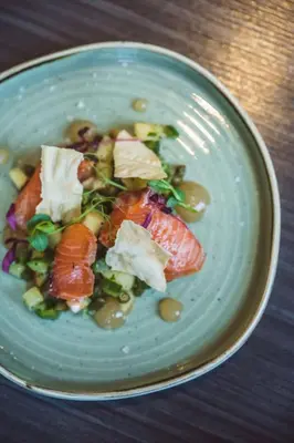 a blue plate of food with vegetables on a table at Doubletree by Hilton Edinburgh City Centre in Edinburgh