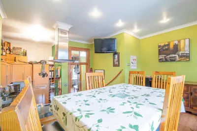 a dining room with a table and chairs and a tv at Almada Apartment in Hamilton
