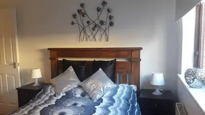 a bedroom with a bed with pillows on it at Sunnyside Apartments in Coatbridge