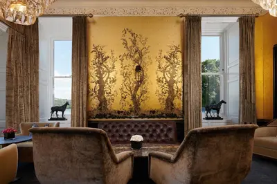 a living room with a couch and two windows at Cameron House on Loch Lomond in Balloch