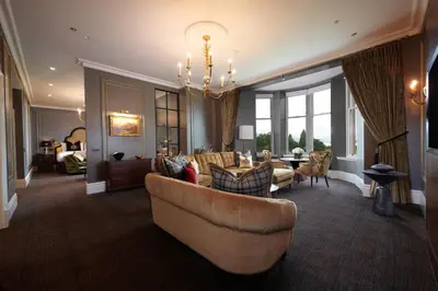 a living room with a couch and a dining room at Cameron House on Loch Lomond in Balloch