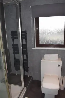 a bathroom with a toilet and a shower and a window at 3 Bedroom-Kelpies Serviced Apartments Bruce in Falkirk