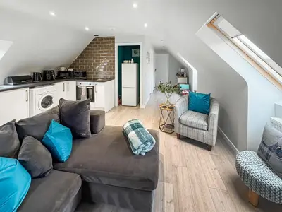 a living room with a couch and a kitchen at The Snug in Harthill