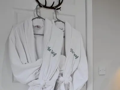 a group of white jackets hanging on a rack at The Snug in Harthill