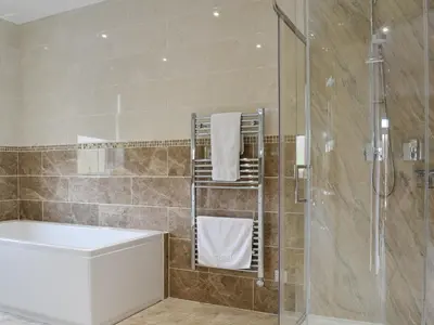 a bathroom with a shower and a sink and a tub at Liftingstane Cottage in Closeburn