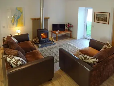 a living room with two brown couches and a fireplace at Charlies Cottage in Muasdale