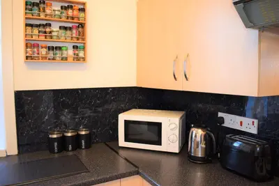 a kitchen counter with a microwave on a counter top at Kelpies Serviced Apartments McDonald- 2 Bedrooms in Falkirk
