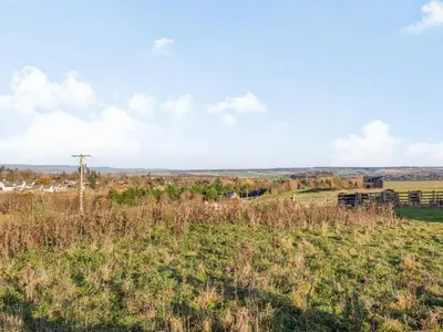 a field of grass with a utility pole in the distance at Woodend Barn in Auchterarder